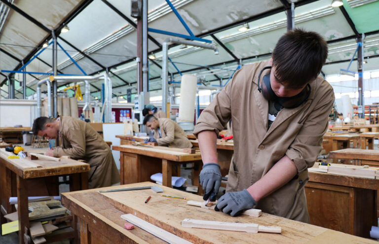 estudiantes de FP trabajan en un taller con madera