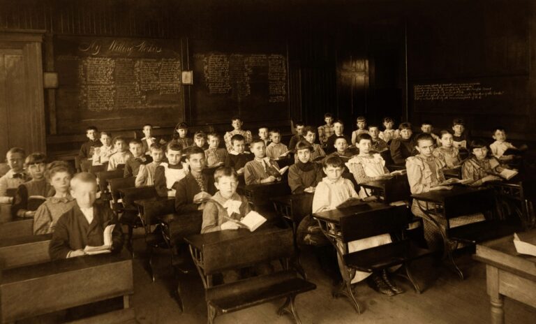 Un aula llena de niñas y niños en una escuela de finales del siglo XIX o principios del XX