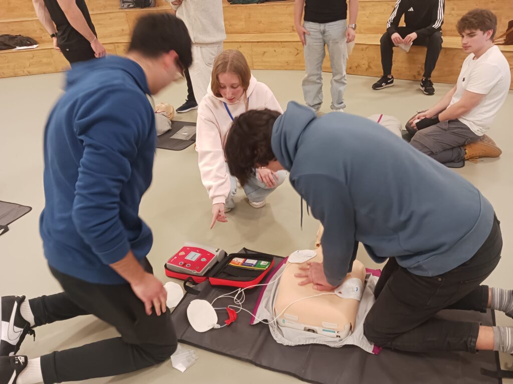 Varias personas jóvenes practicas maniobras de RCP con un muñeco durante un curso