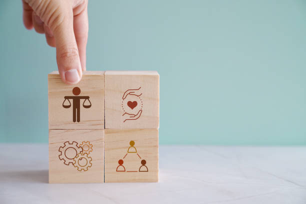 Hand holding wooden block with human scale, business ethics and corporate compliance concept